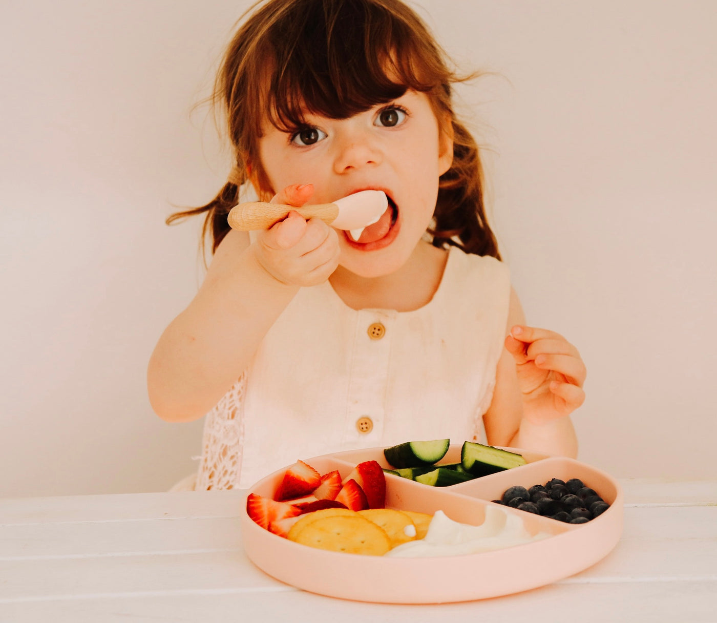 girl using pink divider plate and spoon