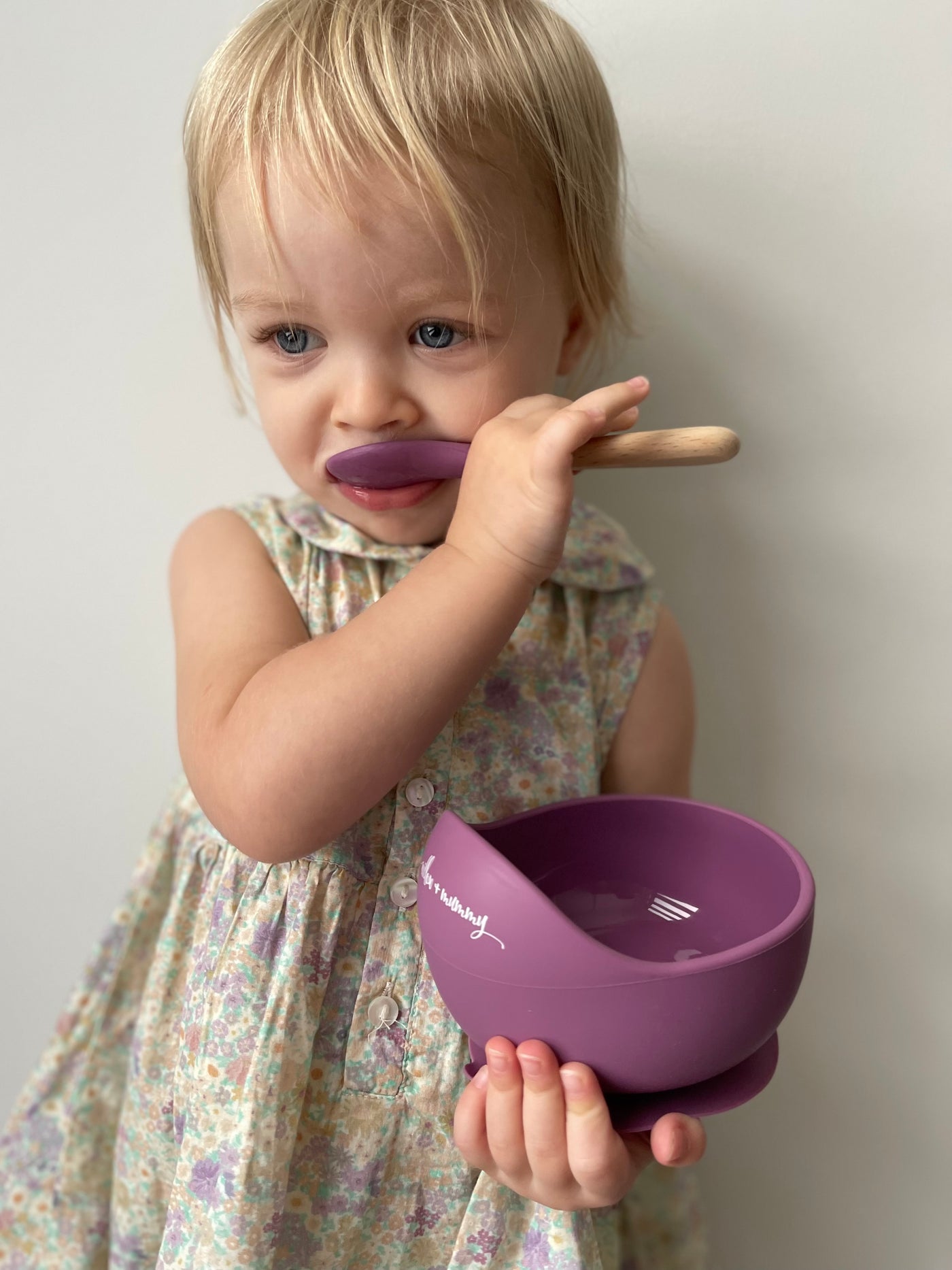 Toddler holding plum silicone suction bowl